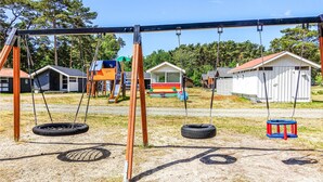 A playground with swings, tire swings, and a slide. - Amazing apartment in Nexø with kitchen (Nexø)