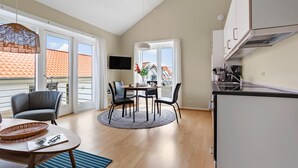 Eine moderne Wohnung mit Essbereich, Küche und großen Fenstern.
