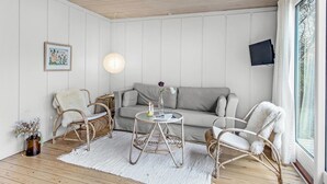 A cozy room with a grey sofa, wicker chairs, a small round table with candles, and a white rug. - Amazing home in Gudhjem with WiFi (Gudhjem)