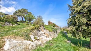 A natural landscape with a grassy path, large rocks, and trees. - Amazing home in Gudhjem with WiFi (Gudhjem)