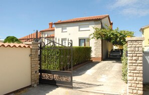 A gated residential area with a white house, a paved driveway, and a parked car. - Gorgeous home in Pula (Pula)