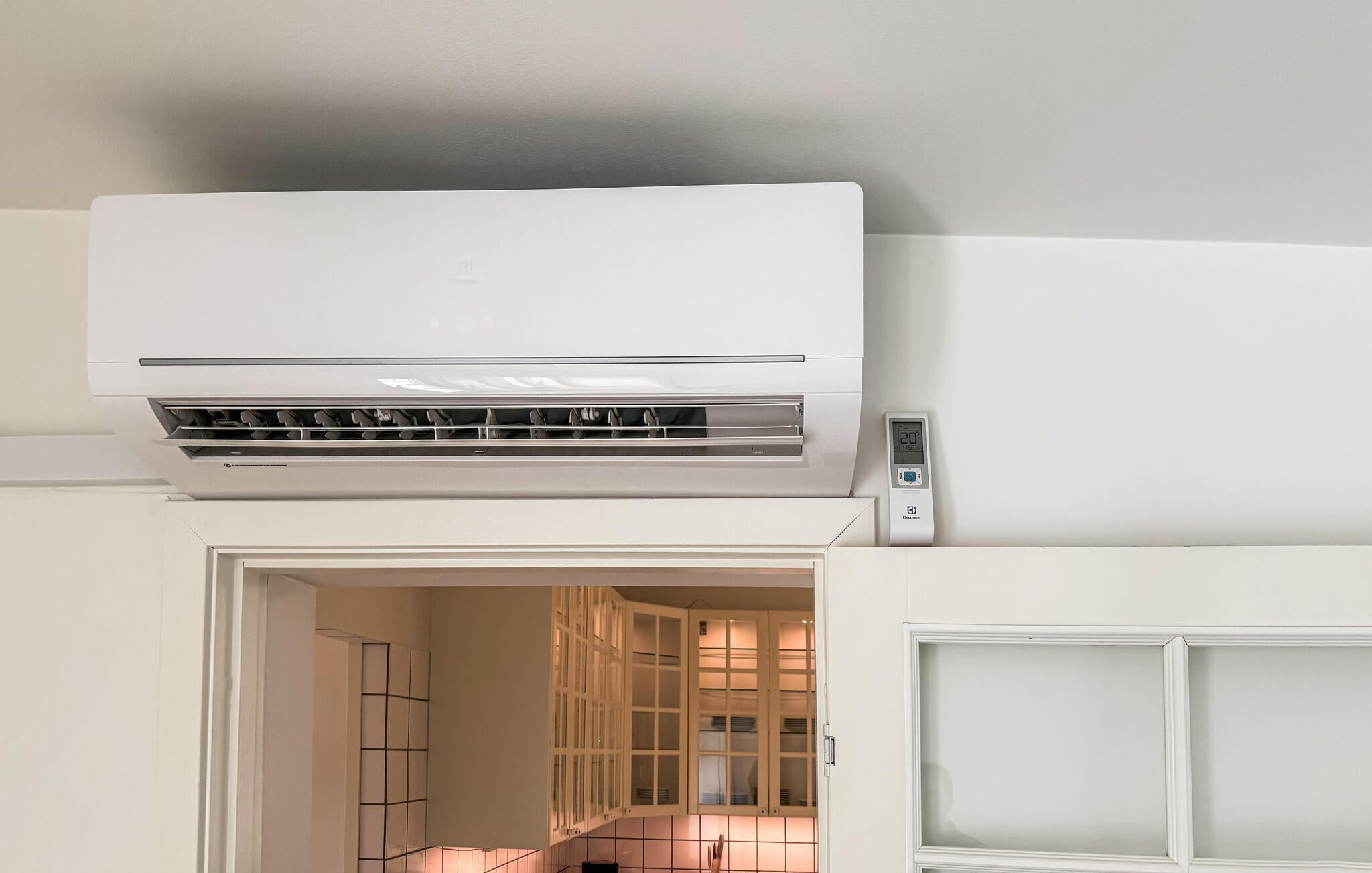 Un equipo de aire acondicionado blanco instalado en una pared con un termostato digital.