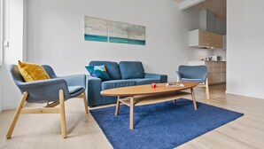 Un salon moderne avec un canapé bleu, un fauteuil bleu et une table basse en bois.