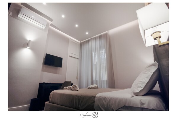 A hotel room with a bed, a TV, an air conditioner, and a lamp. - Room 5 - Double - B&B L'Infinito 88 Charmant Rooms (Napoli)