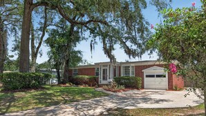 A two-story brick house with a garage, surrounded by mature trees and well-maintained lawns. - Pure GOLD on Emerald Isle - 4BR, Patio, WIFI (Jacksonville)