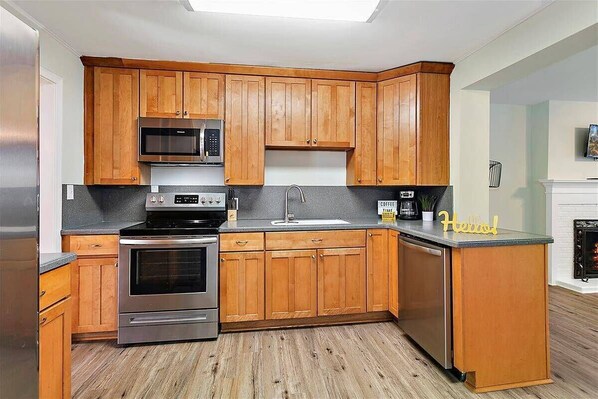 Enjoy cooking in this well-equipped kitchen with appliances, a wooden island, and a sink.