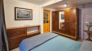 Ein Schlafzimmer mit einem Bett, einem Schminktisch, einem Kleiderschrank und einem Bild an der Wand.
