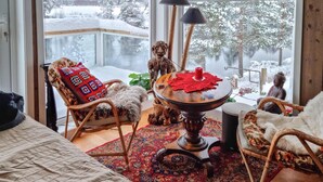 A cozy room with a large window, a wooden table with a red candle, and two wicker chairs. - Gorgeous home in åmli with WiFi (Åmli)