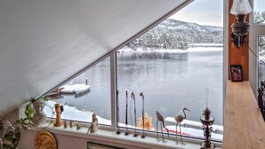 A room with a large window overlooking a lake and snow-covered landscape. - Gorgeous home in åmli with WiFi (Åmli)
