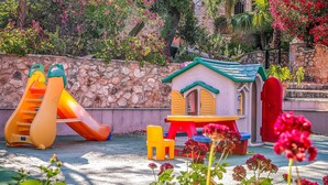 Ein Kinderspielbereich mit einer Rutsche und einer kleinen Spielhaus-Konstruktion.