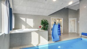 Un baño moderno con una bañera grande, zona de ducha y piscina.
