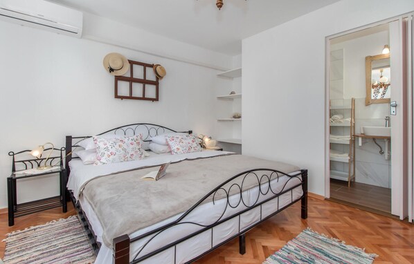 A bedroom with a double bed, bedside tables with lamps, a wardrobe, and a mirror.