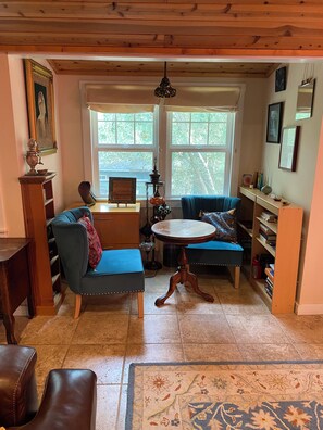 A cozy room with a blue sofa, a round table, and a bookshelf.