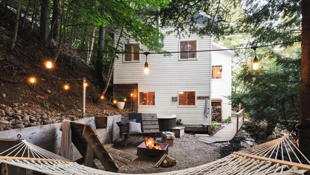 A cozy outdoor area with a hammock, fire pit, and string lights. - Spring Nature Retreat w/Hot Tub Near Owl’s Head (Mansonville)
