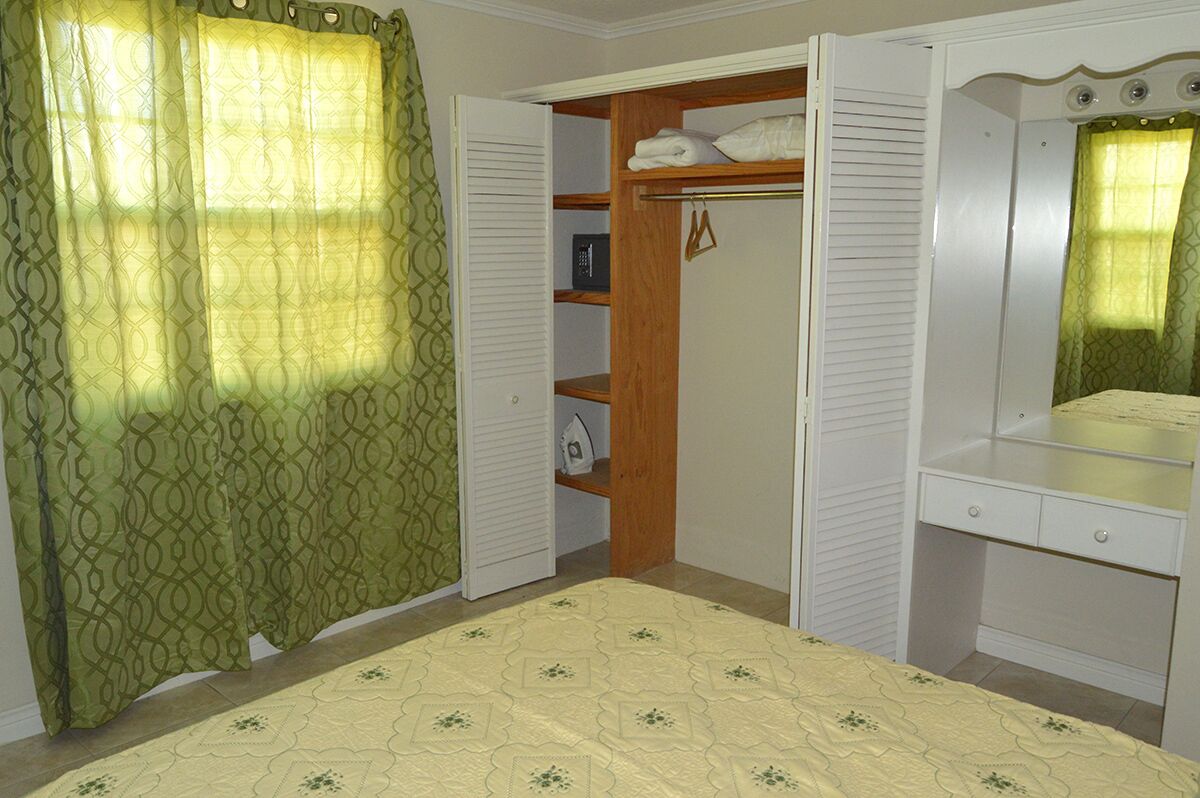 A bedroom with a bed, a wardrobe, and a mirror.