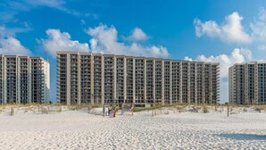 A beachfront hotel with multiple high-rise buildings, sandy beach in front, and clear blue sky. - Phoenix VII 004 Summer vacation dates available. Just steps to Pool and Beach!! (Orange Beach)