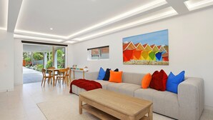 Un salon moderne avec un canapé, une table basse et un coin repas.