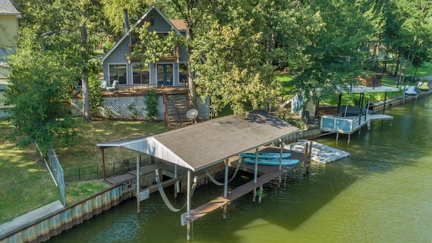 A house with a dock extending into a river, surrounded by trees. - Lakefront Chalet w/ Covered Boat Dock - Sleeps 8 - 1 Hour from Dallas (Malakoff)