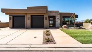 A modern two-story house with a garage, a well-maintained lawn, and a clear sky. - *New Owner Special* - Modern Luxury Casita (Ivins)