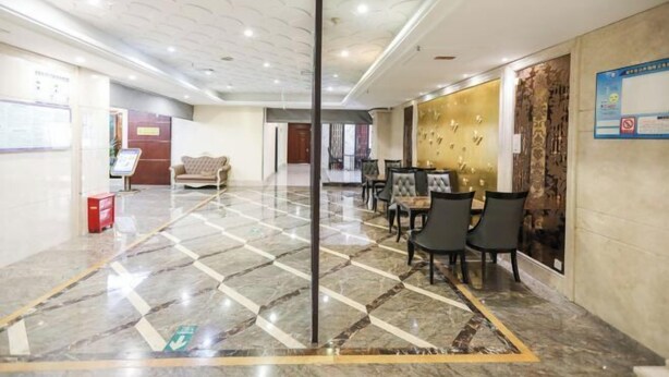 A hotel lobby with a marble floor, a reception desk, a sofa, and a dining area with chairs and tables. - Wenzhou Lima Business Hotel (Binhai Industrial Park Branch, Wenzhou Longwan Airport) (Wenzhou)