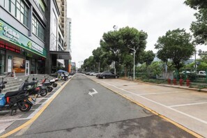 Een straat met geparkeerde motorfietsen, een vrijliggend wegdek en gebouwen met reclameborden.