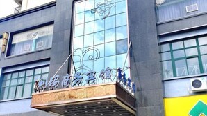 A building with a large glass facade and a sign with Chinese characters. - Wenzhou Lima Business Hotel (Binhai Industrial Park Branch, Wenzhou Longwan Airport) (Wenzhou)