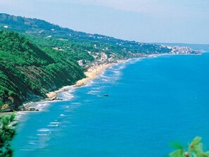 Eine Küstenlandschaft mit Strand, Klippen und blauem Meer.