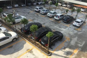 Un estacionamiento con varios autos y pequeños árboles.