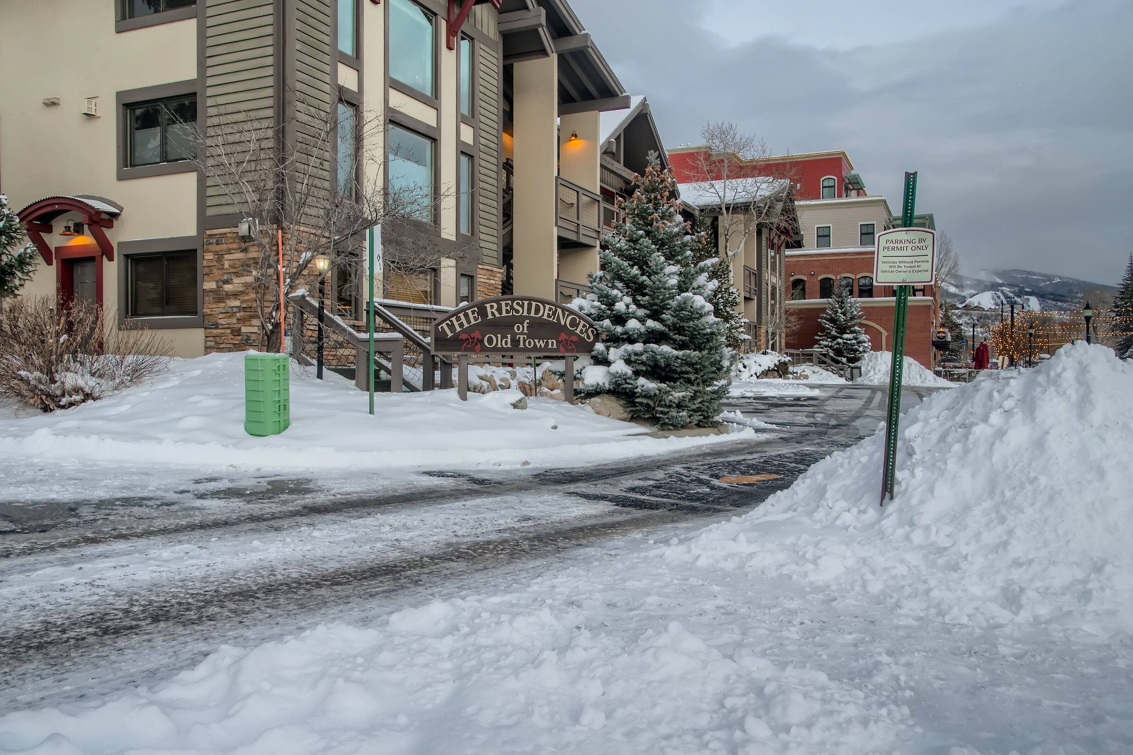 A snow-covered street with a sign for 'The Residences of Old Town.'