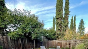 Eine Terrasse mit Steinbelag, einem Feuerkorb und Metallstühlen.