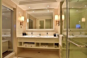 Een moderne badkamer met een grote spiegel, twee wasbakken en een douchecabine van glas.