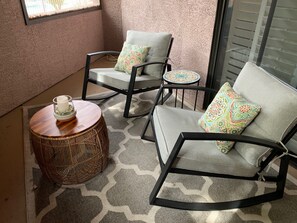 Relax on the balcony with two comfortable rocking chairs and a small table.