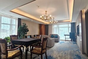 A hotel conference room with a round table, chairs, a chandelier, and large windows. - Dingbang International Hotel (Jingning)