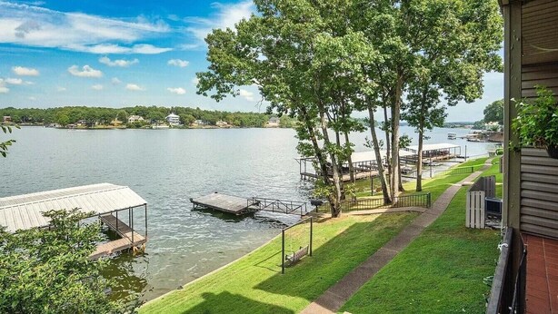 Una proprietà sul lago con un molo, un prato e vista sull'acqua.