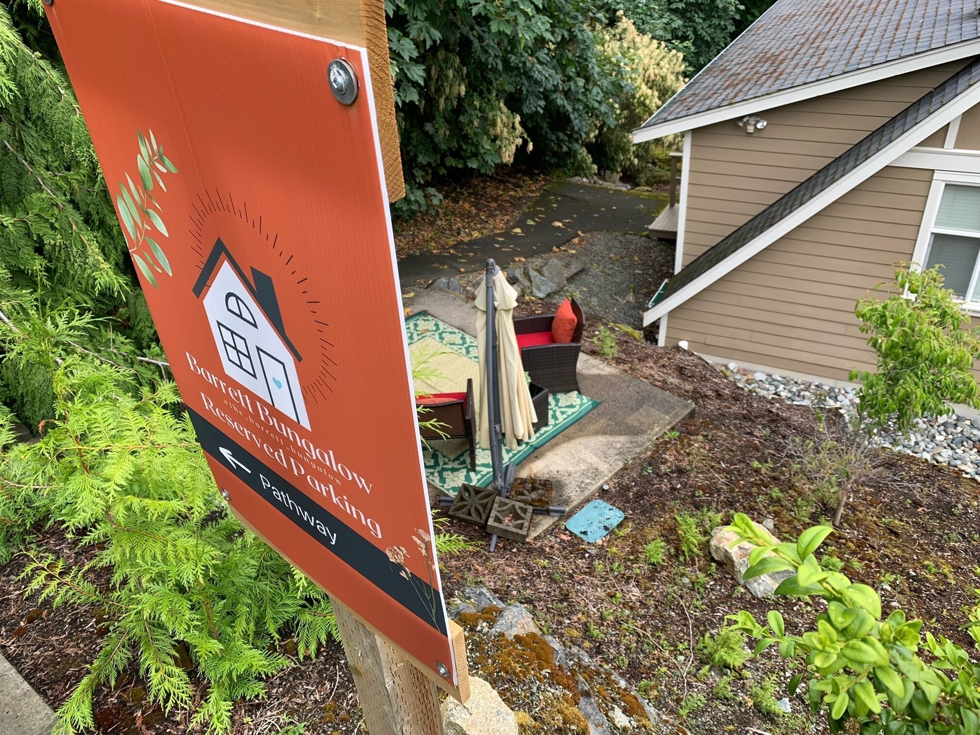 A sign for Barrel Bungalow with a pathway.