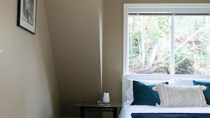 A bedroom with a bed, a nightstand, a window, and a framed picture on the wall. - Quiet, cozy 1 bedroom suite, w/ separate entrance. Now with A/C! (North Saanich)