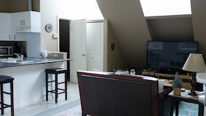 A kitchen with a dining area, a TV, and a small plant on the table. - Quiet, cozy 1 bedroom suite, w/ separate entrance. Now with A/C! (North Saanich)