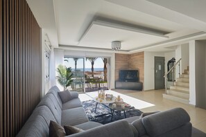 A modern living room with a sectional sofa, a coffee table, and a view of the outdoors.