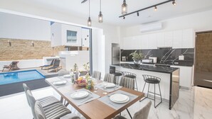 Una cocina moderna con gabinetes blancos, encimera de mármol y horno empotrado.
