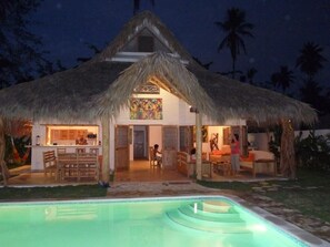 A thatched-roof house with a pool, bar, and dining area. - Pretty Caribbean Style Villa (Las Terrenas)