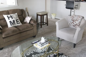 Relax in this inviting living space with a sofa, armchair, and coffee table.