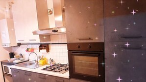 A modern kitchen with stainless steel appliances, a gas stove, an oven, and a sink.