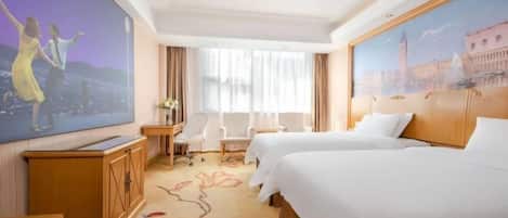 Habitación de hotel con dos camas, un escritorio, una silla, un televisor y un ventanal grande con cortinas.