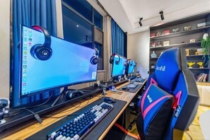 A gaming setup with multiple monitors, a keyboard, and gaming chairs.