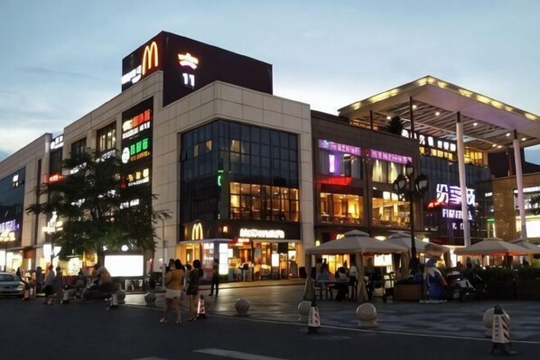 A multi-story commercial building with various storefronts, including a McDonald's.