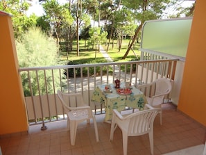 Enjoy a peaceful retreat on the balcony with a table for two and a comfortable seating area.
