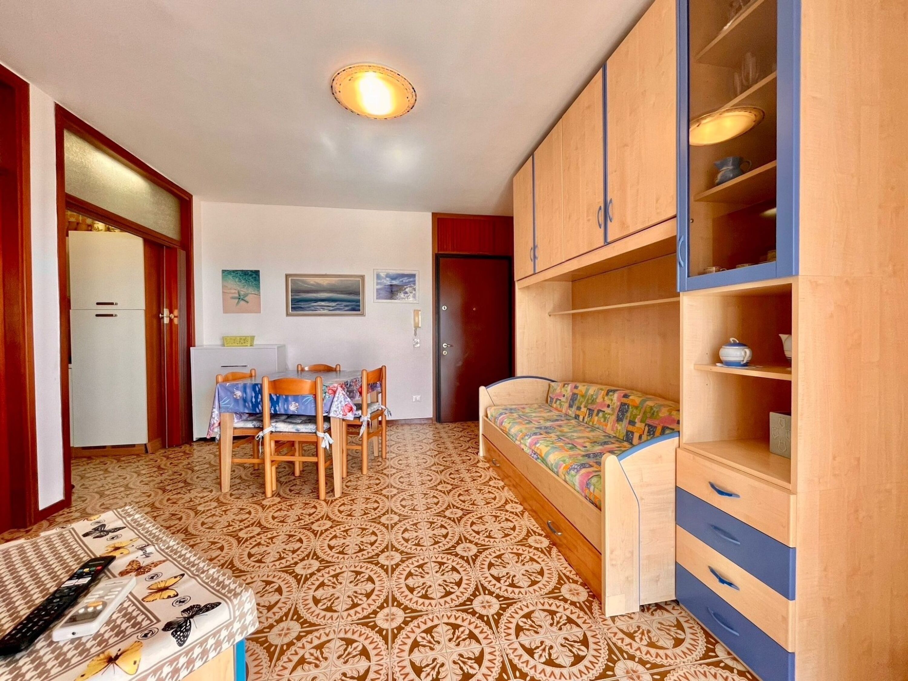 A compact living space with a dining area, a sofa, and a kitchenette.
