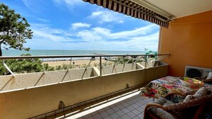 Ein Balkon mit Blick auf Strand und Meer.