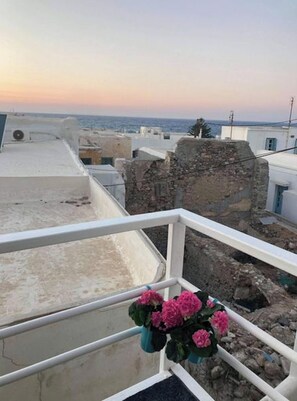 A balcony with a view of a coastal town, including buildings and a clear sky. - Studio Seagull - By Old Market Street - Naxos Town (Naxos)