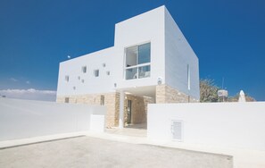 A modern white building with a stone base, large windows, and a flat roof. - Protaras Vie Bleu Villa Vb4 (Paralimni)